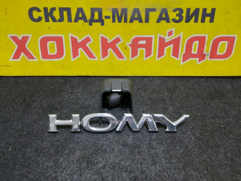 Эмблема Nissan Homy задняя