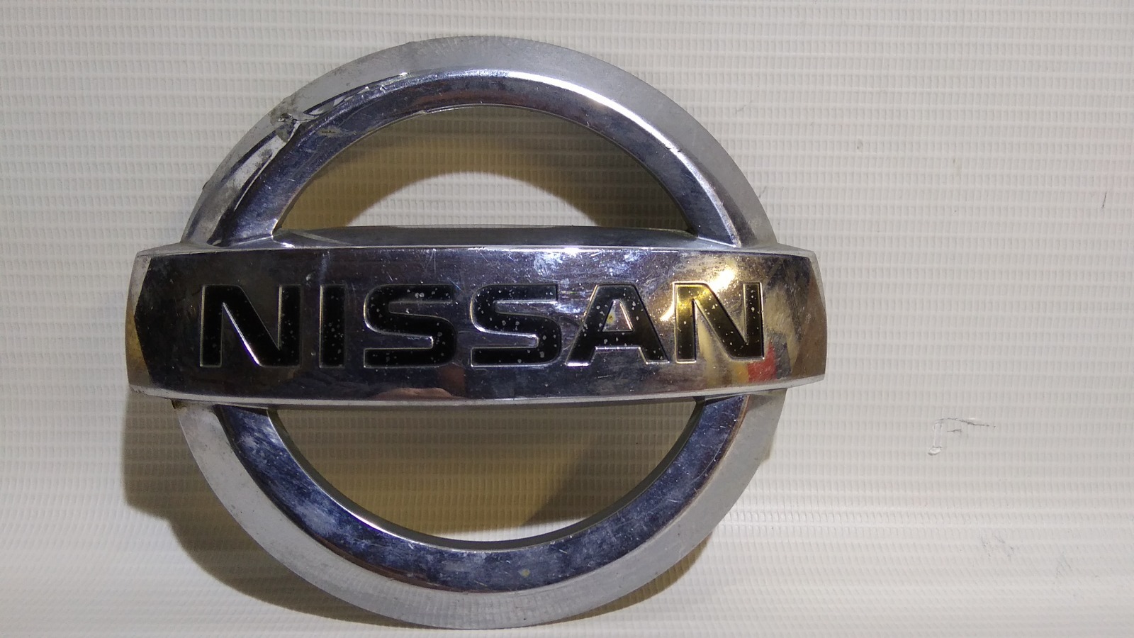 Эмблема Nissan Note E11 HR15DE 2005 передняя