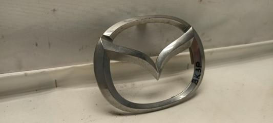 Запчасть эмблема передняя Mazda