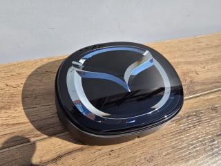 Запчасть эмблема передняя Mazda Axela 2016-2019